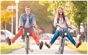 Mlad par vozi bicikle po gradu