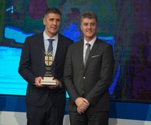 dva muskarca u crnim odelima na konferenciji dodeljuju nagrade