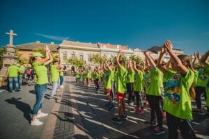 Deca u zelenim majicama vezbaju na trgu